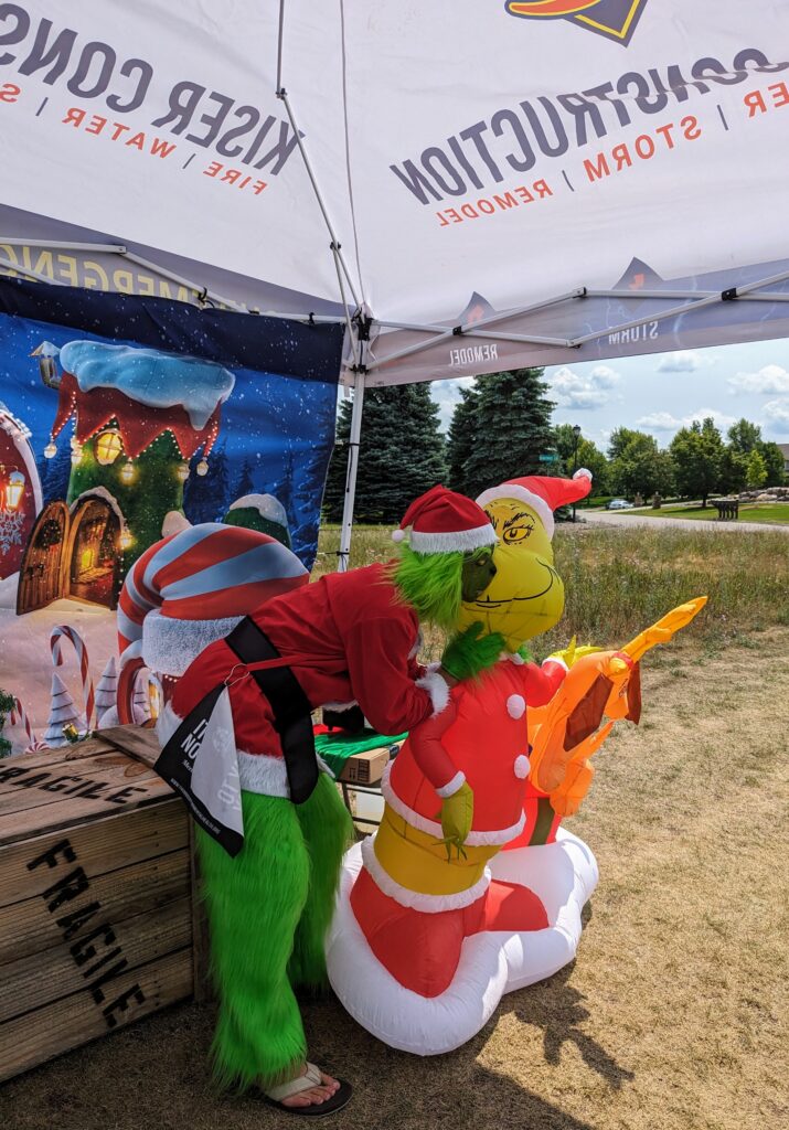 PXL_20230713_181411431 the grinch at the kiser construction christmas trees and tees photo booth